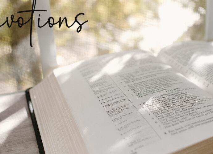 An opened bible on the table with the word devotions written across it.