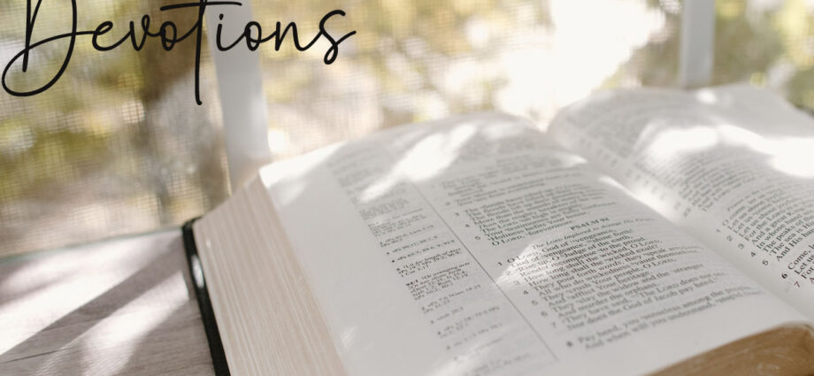 An opened bible on the table with the word devotions written across it.