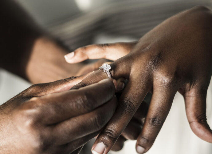 groom putting wedding ring on the bride