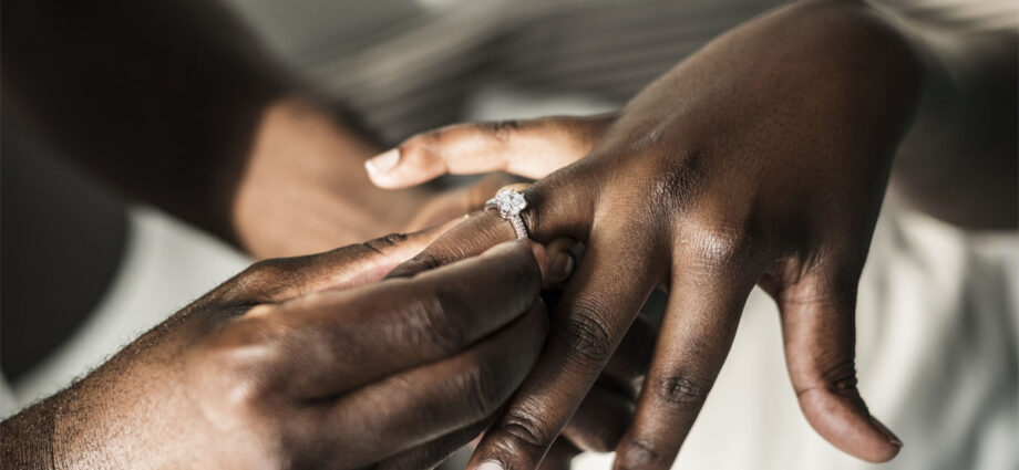 groom putting wedding ring on the bride