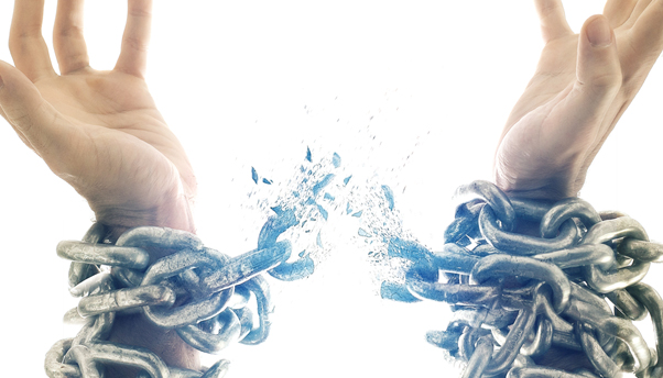 Hands breaking free of chains symbolizing the freedom and deliverance of Christ