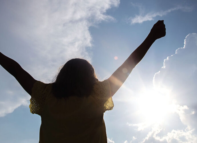 Christian Woman praising God with arms stretched wide