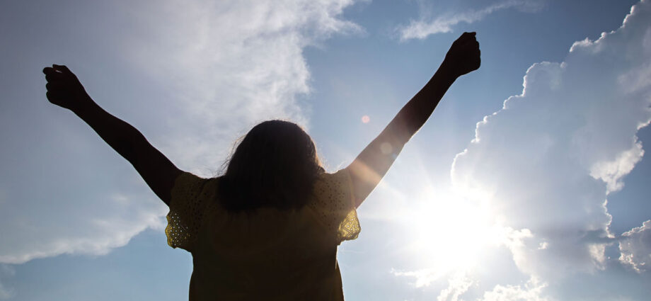 Christian Woman praising God with arms stretched wide