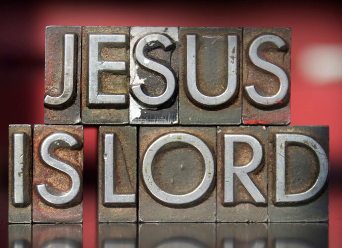 hues of red background with medal words that say Jesus is Lord