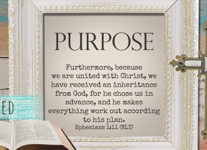 background of multicolored old wood with a cross, open bible, and the words of Ephesians 1:11.