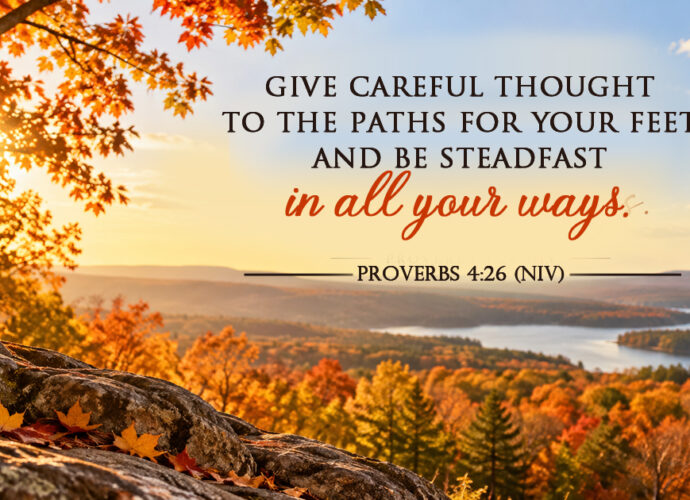 A peaceful autumn landscape on a bright sunny day, overlooking colorful fall trees, distant hills, and a winding lake, featuring Proverbs 4:26 NIV.