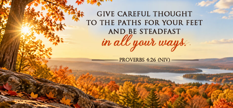 A peaceful autumn landscape on a bright sunny day, overlooking colorful fall trees, distant hills, and a winding lake, featuring Proverbs 4:26 NIV.